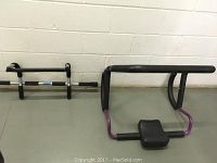 Photo of both workout equipment: pull up bar and abdominal worker, placed against a wall