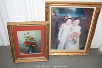Photo depicting both framed prints side by side on the floor showing size difference and condition of frames.
