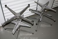 Four aluminum star chair bases stacked