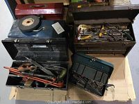 Overall view of five open tool boxes filled with assorted hand tools including wrenches, pliers, files, and screwdrivers.