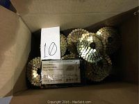 Box with multiple rolls of galvanized roofing coil nails with label showing quantity and size details.