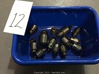 Tray holding 13 metal drill chucks showing a variety of sizes and types.