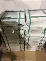 Stack of white cardboard boxes strapped with green plastic bands