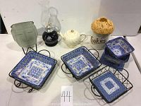 Full view of all items showing candle holder, teapot, cookie jar, trays, and hurricane lamp