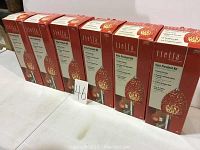 Six unopened Tiella Vela pendant light kits in original boxes, each box shows the red and white spotted glass pendant.