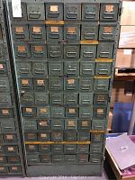 Front view of green steel cabinet showing six columns and eleven rows of bins.