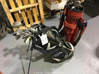 Two sets of golf clubs, one in black and beige Callaway bag, one in red golf bag.
