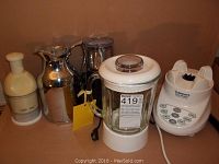 Four kitchen items arranged on a table: stainless steel Thermos coffee holder, Hamilton Beach coffee grinder, Quick Chop chopper, and a Cuisinart blender.