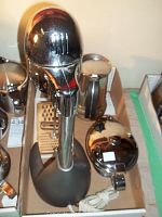 Salton DM-11 drink mixer with chrome mixer head on black stand, power cord visible, metal grater behind
