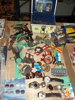 Full overview photo displaying the collection including wristwatches, old coins, watch wrench tools, German badges on colorful ribbons, and small memorabilia items on a table.