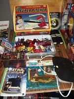 Overview of multiple toys and collectibles including Super Pitcher toy, Hot Wheels cars, Star Wars action figure, Star Trek glass, knife, and playing cards.