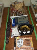 Wide view showing belts, golf balls box, golf tees, and board game