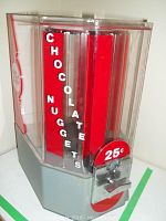 Front view of the acrylic and metal candy dispenser showing 'CHOCOLATE NUGGETS' text and coin slot.