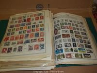 Photo of a large album containing USA and world postage stamps arranged on pages.
