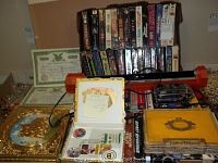Photo showing VHS tapes in two boxes, stock certificates, horse art, and the red light tube on a table