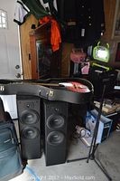 Overall view showing guitar in case, two speakers, and microphone stand