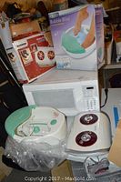 Photo showing Kenmore microwave oven, HoMedics Shiatsu Foot Massager, and Bubble Bliss Foot Spa, both massager items shown partially in and out of box