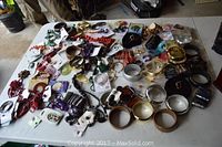 Table displaying large variety of costume jewelry including bracelets, necklaces, earrings, and pins scattered across the surface.