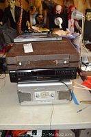 Sony CD changer CDP-CE245 and Teac stereo unit stacked with Smith Corona typewriter case on top, assorted background