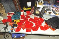 Photo showing Booster PAC battery pack, drills, multiple red Huot steel drill index boxes, and drill bit sets displayed on table.