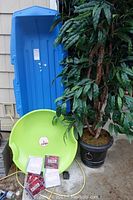 Blue Paris Expedition sled, green Flexible Flyer round sled, faux tree, and Backstreet Boys CDs displayed together.