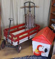 Full lot showing vintage wooden wagon with removable sides, wooden sled with metal runners, and Snoopy toy box with red roof.