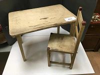 Vintage child's folding table and single chair set, primitive style, on display with dark backdrop.