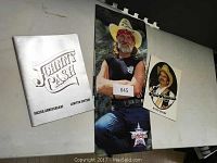 Photo showing the Johnny Cash limited edition program, Willie Nelson and Merle Haggard programs arranged on surface.