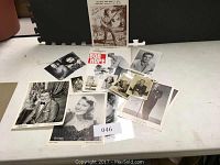 Collection of various signed celebrity photos including Janet Leigh and Pattie Page, Bob Hope program and others spread on a white surface.