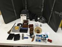 Full assortment of men's vanity, leather goods, binoculars, and collectible items arranged closely together.