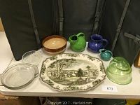 Full lot overview with all items visible on table including Johnson Ironstone platter, mixing bowls, pitchers, glass pie pans, citrus juicer.