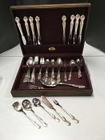 Full view of 56-piece International Silverplate DeepSilver flatware set in wooden storage box with burgundy fabric lining.