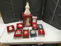 Overview of 9 Lenox Christmas decorations and boxed ornaments on table.