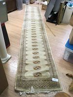 Full length view of the cream and beige woven runner rug laid out on wooden floor, showing entire runner and pattern.