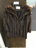 Front view of the dark brown vintage mink fur coat hanging on a hanger.