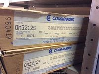Photo of two stacked original cardboard boxes labeled Commander QM32125 breaker panels.