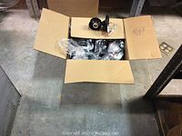 Box with open top showing multiple Leviton light fixture components including wiring and mounting hardware.