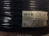 Full view of black cable spool with manufacturer label YR20660 010 (BLK) FT and shrink wrap