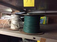 White and green wire spools on shelf