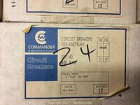 Close-up of one box label showing Commander branding, 2-pole 40 Amp, 120/240 V, qty 12