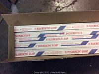 Top view of open box showing fluorescent lamp tubes in white packaging labeled 'Fluorescent Lamp'.