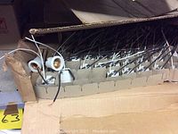 Photo of a box with multiple white electrical light sockets with wiring on a shelf