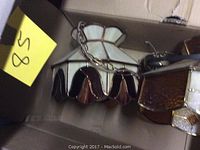 Two Tiffany style hanging light fixtures placed inside a cardboard box, showing stained glass shades and metal hanging chains with partial view of the chains coiled