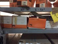Shelves with boxes of electrical receptacles labeled PS 3550, 3331, and others, some handwritten labels visible on shelving.