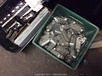 Two containers shown; one with assorted metal conduit fittings, another with many circuit breakers and electrical panel components
