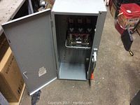 Open metal electrical cabinet showing interior components of the 200 amp 3 phase switch.