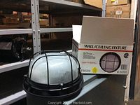 Four black metal wall or ceiling light fixtures with ribbed glass domes, shown next to an unopened box marked 'Wall/Ceiling Fixture' with model number 92318