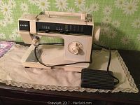 Front view of the Singer electric sewing machine showing stitch selection panel, rotary dial, needle area, and foot pedal.
