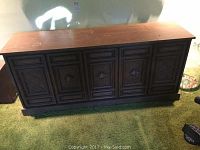 Full front view of the vintage wooden 8-track turntable record player cabinet showing carved panel doors and wood finish.