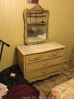 Photo of full dresser with three drawers and the mounted ornate mirror showing overall condition and design.